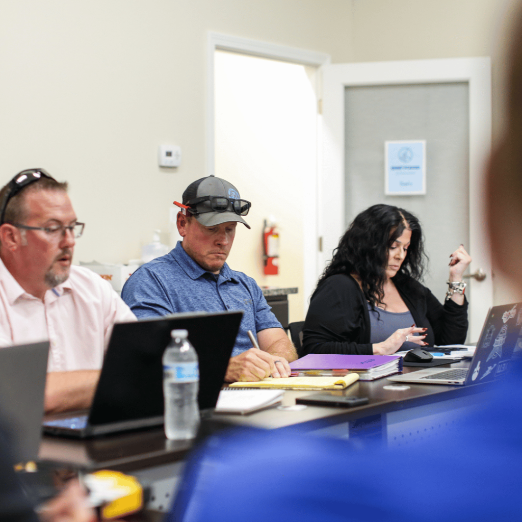 Clarkson Pools team members in a strategy meeting, collaborating on pool design, construction, and customer service improvements.