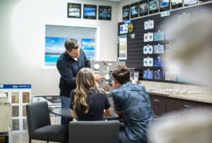 Clarkson Pools design consultant reviewing pool equipment and options with homeowners in the showroom.