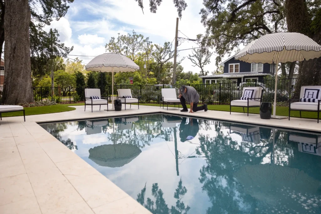 Clarkson Pools service technician checking coping at residential backyard pool