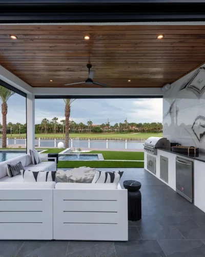 Modern outdoor living space with covered seating by Clarkson Pools.